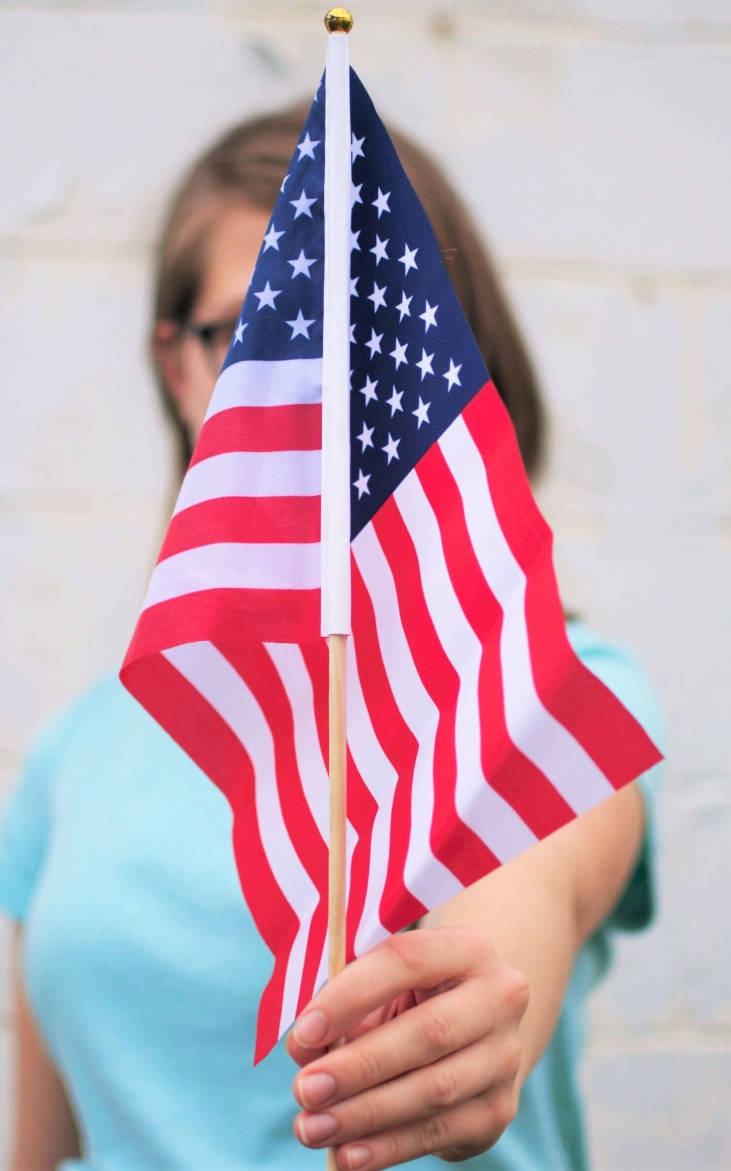 A white woman holding an American flag. 