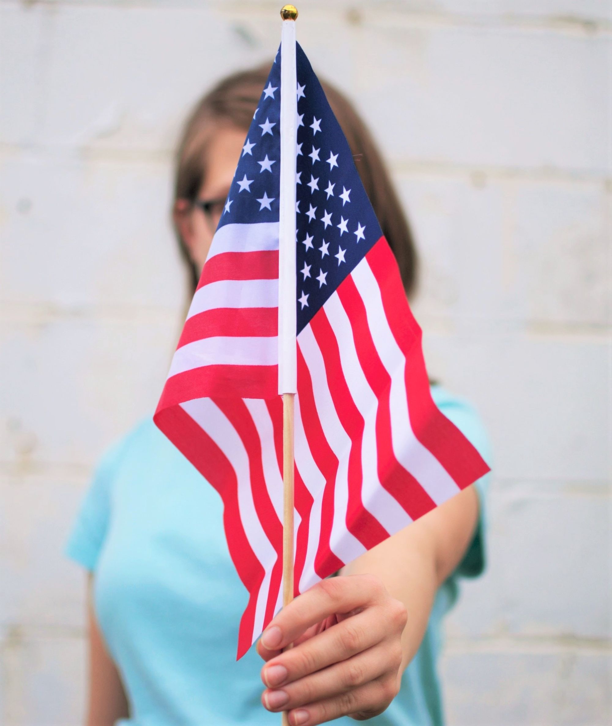A white woman holding an American flag.